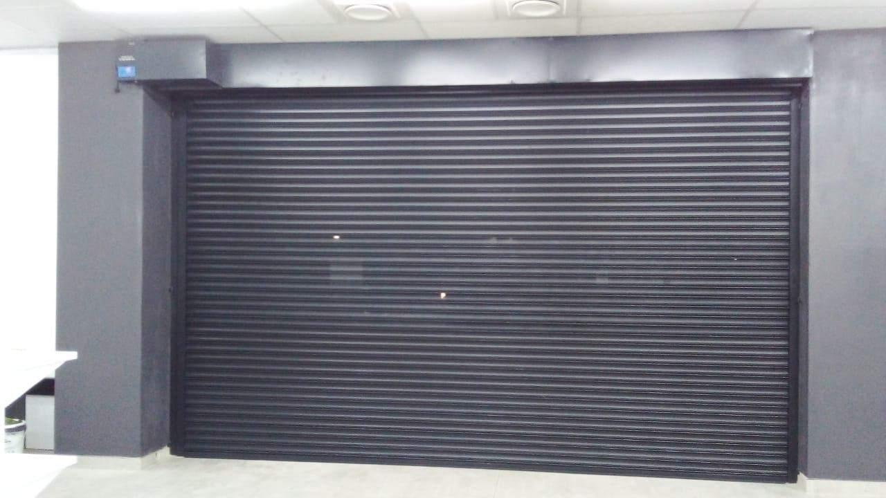 Dark ribbed roll-up garage door fitted to a modern double garage